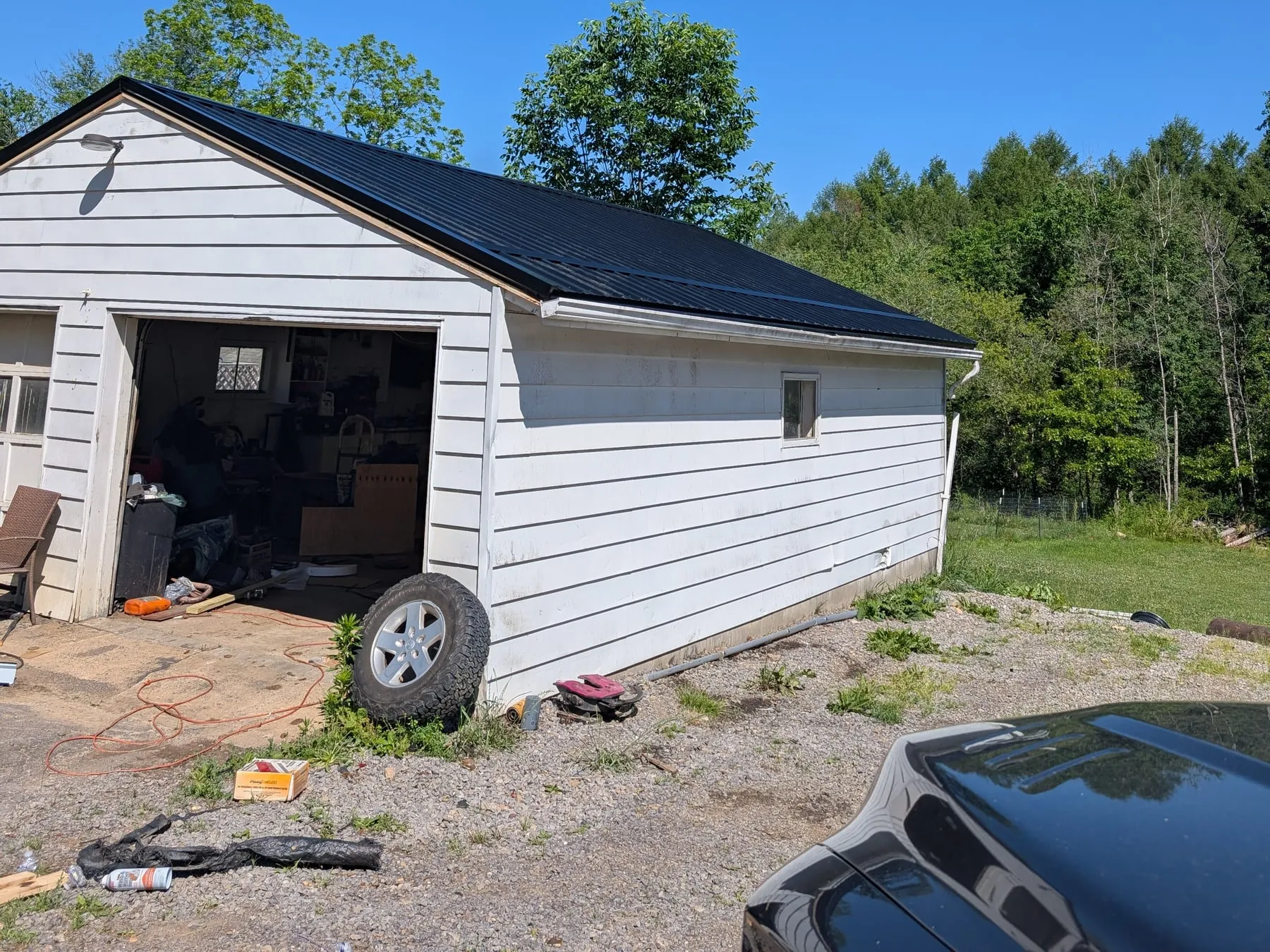 The same garage with a new black metal roof